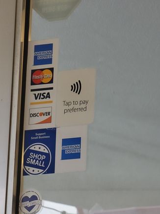 Tap to pay sticker on entry door (one above the "Shop Small" logo, right of the networks)