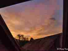 Colourful sky at the dusk over the daughters' bed, through our roof.