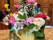 Joyce and Michaela picked flowers from her gardens and put together the three vases in front. Joyce loves flowers!