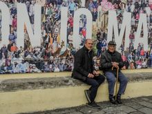 Locals pose for us by a massive mural.