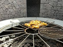 Demonstrating cooking chicken over the heat emitted by the volcanic embers.  (Food served in the cafe includes food cooked in this manner)