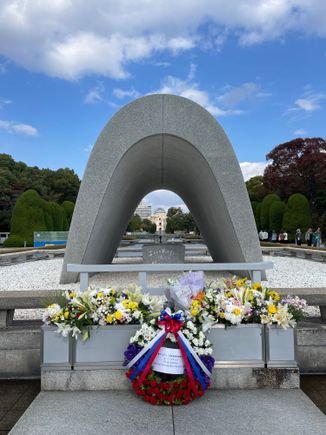 The cenotaph monument is aligned to frame the Peace Flame and the A-Bomb Dome. 