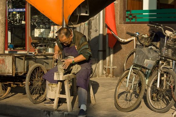 Bike repairman on Di'anmenwai Dajie road.