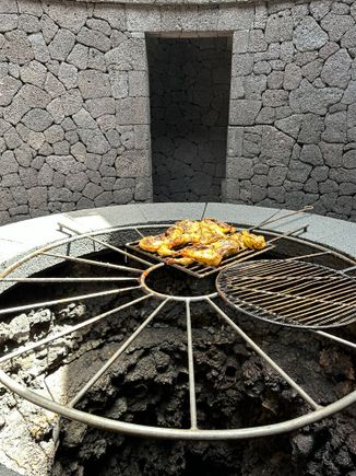 Demonstrating cooking chicken over the heat emitted by the volcanic embers.  (Food served in the cafe includes food cooked in this manner)