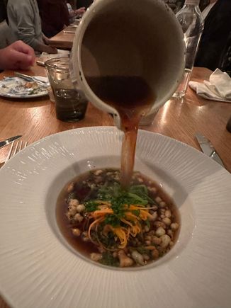 Consommé being poured into my bowl