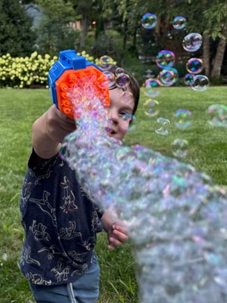 Playing with his new bubble gun!