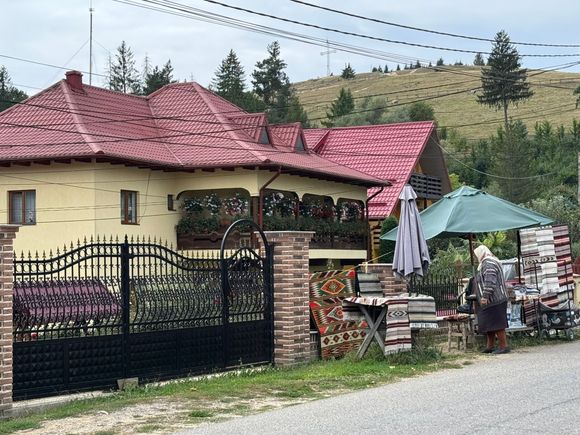Romanian home with an elderly woman selling her goods.