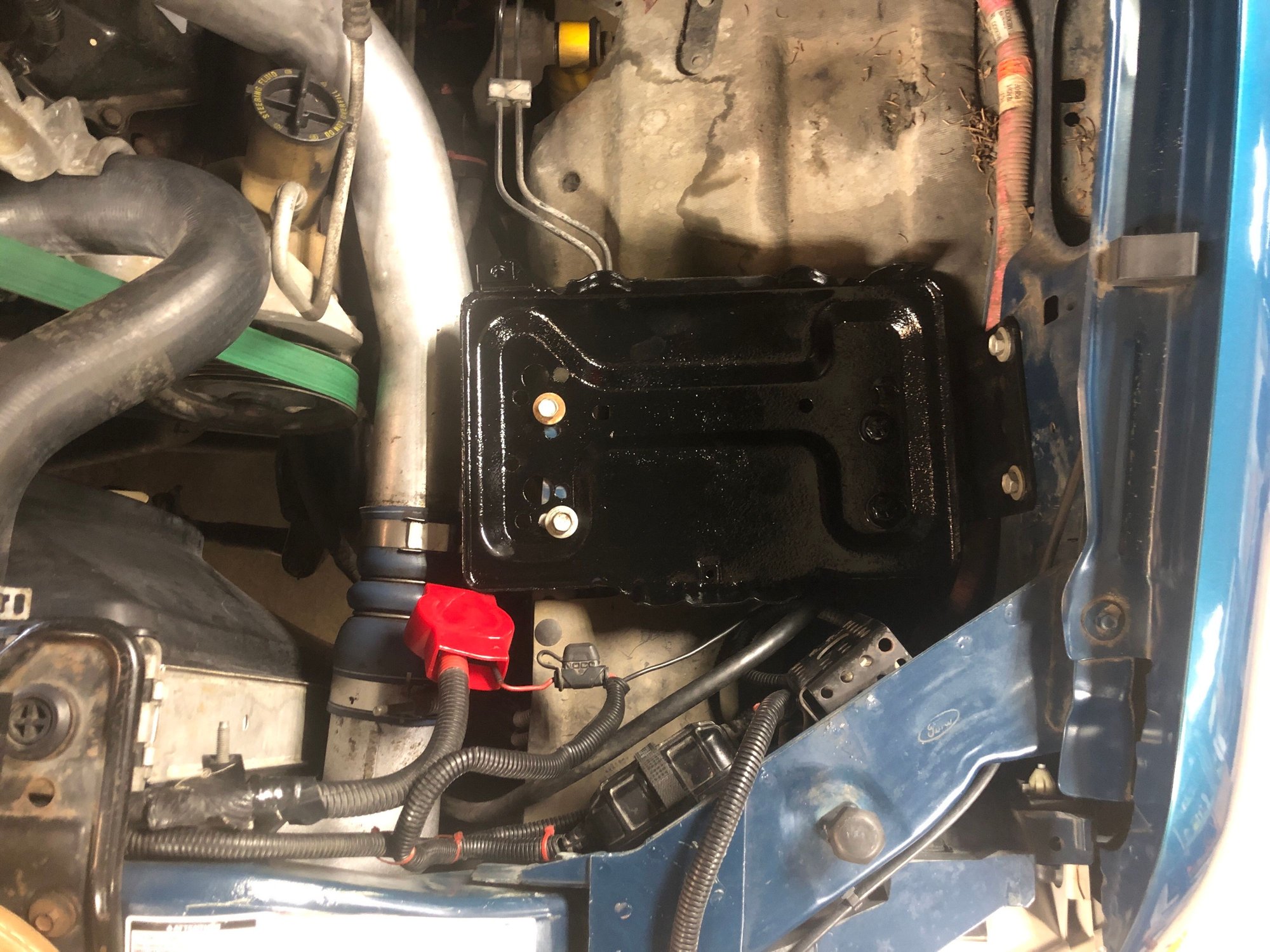 Engine side is slightly forward of fender side. Looking at the passenger side battery it appears to be the same. Engine side is slightly forward. 