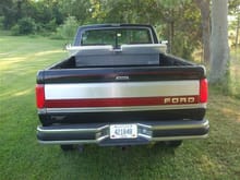 rear view. Worked over tailgate strip and tail lights with a headlight refinishing kit. When the truck was repainted, there was overspray on the tailgate panel. Painted area under step cover with black Hammerite. Added tool box.