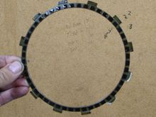 first plate, narrower than the other 8 because it houses an anti rattle spring for the entire clutch pack. The other 8 friction disks have 2x the amount of fiber..