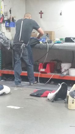 stretching on the foam and stapling onto the hard plastic "frame" of the seat bottom.