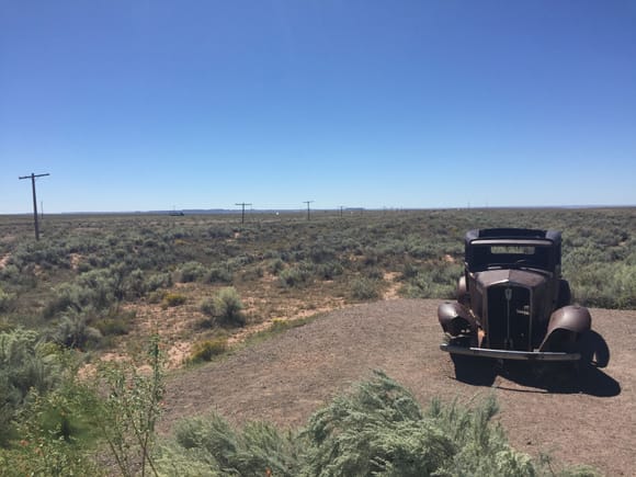 Those telephone poles where right beside US Route 66. The old car is a monument to the road.