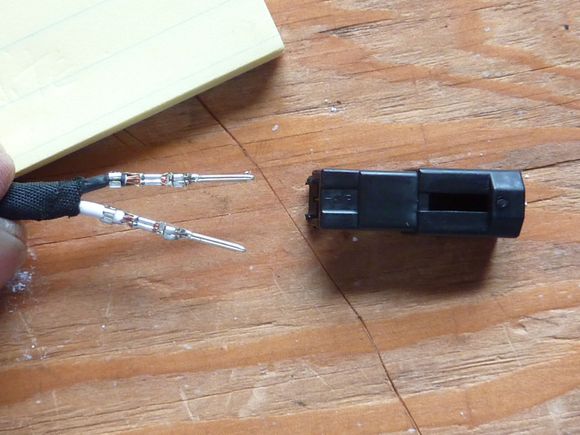 While pressing on the pin release tabs gently pull the wires one at a time out of the plug.