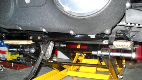 Good shot of Dyan mod, moves pads to miss the Dyna oil pan which drops down below the frame.
Bought 5 1/2" long 1/2" dia. bolts (drilled out holes a bit) to move the pads. Looks like 5" long would have worked. Just measure your pads to see. I also think the stock dia size would be fine, and would save drilling. But others told me to upgrade to 1/2" dia. so I did but they are only slightly larger than the stock bolt dia. It is mainly the extra length you must have. Go with 1/2" if you feel the weight of the bike is going to cut off the stock dia. bolts (which I doubt)  Had to cut off the end of bolt by jiffy stand brace ( I could have just turned the bolt around). 
Put plywood pads to raise it up a bit so lift pads would miss clutch cable underneath. Put scrape leather strips on plywood to keep from slipping. Holds good.

DO NOT BUY THE ALUMINUM MODEL, I have heard that it sways and is flimsy. It is not even built the same design so I don't know if it could be Dyna modified.

HARBOR FREIGHT BIKE LIFTS
Steel one $89 usual, some sales for $79.
Item # 2792 Manufacturer: Central Hydraulics <-GOOD, LIKE MINE

Aluminum one  $More but not as good
Item # 94715 Manufacturer: Central Hydraulics <-BAD, DO NOT