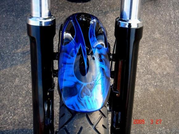FRONT FENDER PAINT
Airea 5150 - Painter
Black Base with Dark Blue Ghost Flame
Silver Metal-Flake Tribal Flame w/ Air-Brushed Skulls
Cobalt Blue Candy over Tribal Flames then Pinstriped
Several Coats of High Gloss Clear Coat
Modified for 21" Wheel (vs 19" stock)