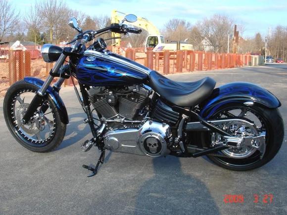 LEFT SIDE
Renegade Elite Wheels and Rotors
Legends Adjustable Rear Air Suspension
HHI Front Roadlock and Drive-Side Rear Brakes
HHI Custom Trees - 5deg, Mid-Glide, Black
Custom High-End Seat and 5" Bobbed Rear Fender
H-D Belt Guard and Axle Cover w/ Custom Inlay and Skull
Skullman Derby Cover and Kuryakyn Hand and Foot Controls
Powdercoated Lowers, Headlight Shell, Bars, Speedo, etc.
Airea 5150 Paint Set - Tribal Flame Candy with Skulls