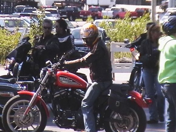 wife and i on are harley in the back ground