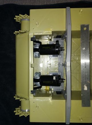 Motors sitting in mounts close up , ruler for scale. 