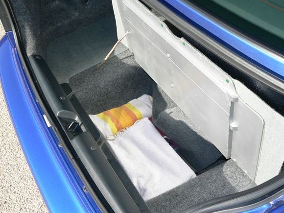 Modified spare tire cover.  I reinforced the cover with some plywood, and added a hinge.  This allows easy access to spare tire well, and provides a nice covered storage area for detailing supplies, valuables, etc.