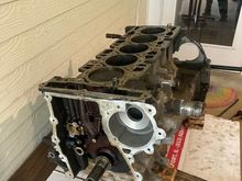 Engine on work bench; wood underneath ensures the weight of the block is not applying pressure on the crankshaft.  