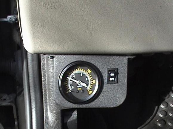 Guage ON/OFF Switch directly in front of the Parking Break. Takes time to adjust without kicking down the guage. Need muscle memory, it turned out to be a perfect spot.