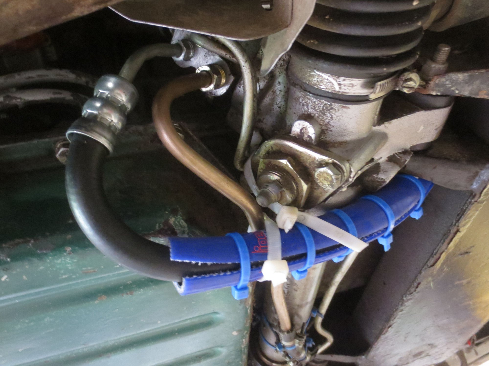 The front of the car is on the right in this photo. The photo shows the hose fixing to the rack tower (the hose connectors face reawards on RHS cars). The hose fllexible is bent through 180� and goes under the rack towards the front. I have protected it with a silicone hose where it goes under the rack.