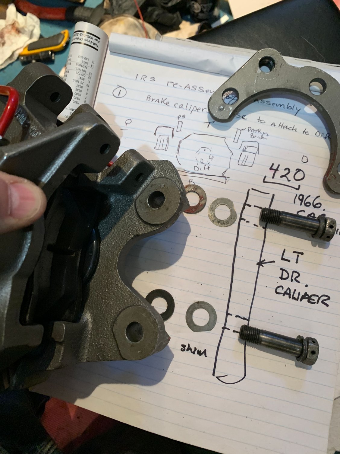 The shims + spacer fit unto the caliper with the bracket 