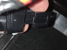 9. There is a tab on the top of this connector (tilted toward the camera in this shot); the tab must be pulled away from the connector body to release the connector from the metal tab it hooks onto.