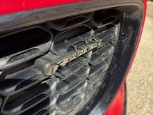 Cable ties looped through the grill and pulled tight to "clamp" the badge in place while the epoxy cured.