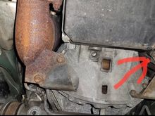 From your perspective, that arrow is pointing towards the passenger side a T25 or T30 Torx screw. Remove that screw and I believe you just pull down on the gray/silver fiberglass panel. 