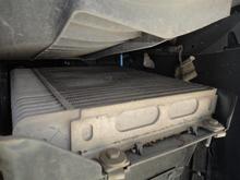 This is the same auxiliary radiator with the plastic inner wheel well pulled toward the tire.  It exhausts air through the grill inside the wheel well toward the front.  Depending on your model, there may be a second auxiliary radiator on the left side.  My car does not have one, but it is depicted in the IPC.  The aux radiator is in addition to the intercooler radiator in front of the radiator.  