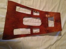 Wood trim fits around gearshift lever.