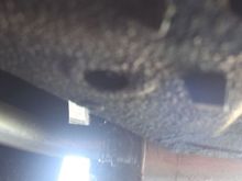 The Drain Tap for the Sump Tank is in that hole which is covered by a rubber grommet and the Tap is undone with a Socket