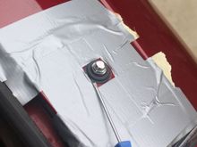 Using a small Screwdriver to ease the Rubber Grommet into the hole
The tape was there to protect the Paint in case the Screwdriver slipped