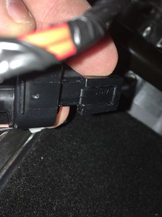 9. There is a tab on the top of this connector (tilted toward the camera in this shot); the tab must be pulled away from the connector body to release the connector from the metal tab it hooks onto.