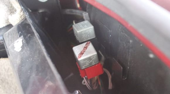 The Red Relay is the Main Relay and the Black Relay is the Fuel Pump Relay.
You can leave the Plastic Cover in place unless you are planning to change one.