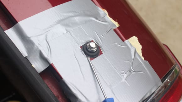Using a small Screwdriver to ease the Rubber Grommet into the hole
The tape was there to protect the Paint in case the Screwdriver slipped