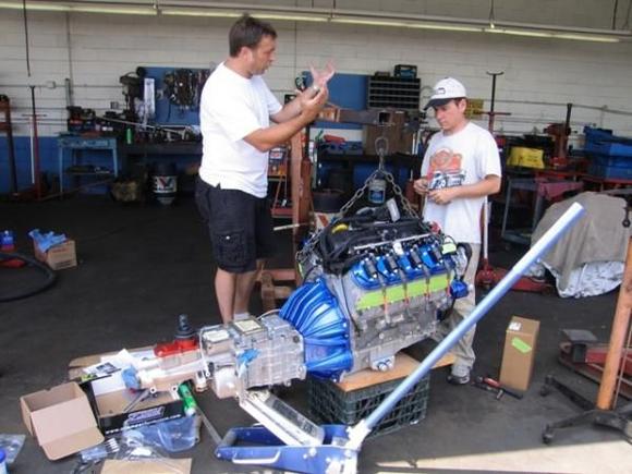 So, there it is, already for installation.  Here is my brother chatting with Luke, the owner of the company who produces the Lister replicas, who is explaining the "simple" technique of slipping the engine and trans into the body shell:

Piece of cake - lets get started!