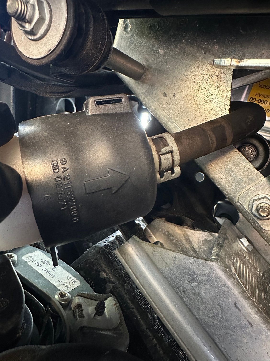 Exposing the silver spring clamp at the TOP of the rubber boot, for removal.
