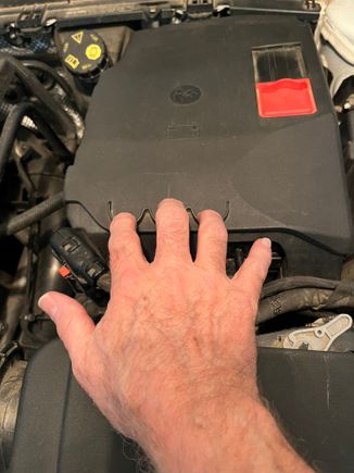 The battery is under the cover with the jump start positive connection. Pull toward you with the 3 semicircular finger grips.