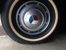 All four tires have original hubcaps and whitewall tires