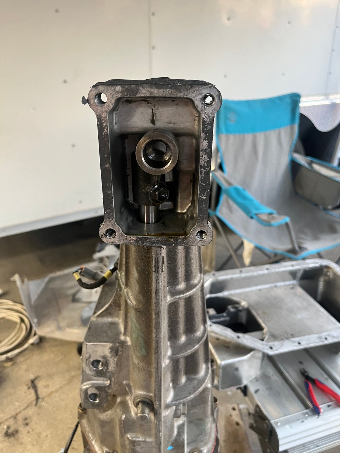 Remove the upper half of the shift box and then remove the bolt holding the shift cup to the shaft (12mm head)