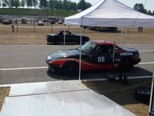 Maggie and the cheetah miata last summer at NHMS for a track weekend.  First time we got to use the new tow setup.  2008 volvo semi truck with sleeper cab.  Air conditioned car hauler trailer with a lift built in.  We brought 4 miatas that weekend in that trailer.  Hanging a hammock between the lift uprights made a great place to sleep.