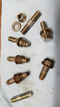 Comparison of original cat-to-header joint fasteners.  There is a stray new nissan turbo stud I got that I was going to use before opting for all stainless here also.  The demon bolts came loose with a snap like I broke the bolt but just "broke" loose.  Notoriously difficult. For some reason one stud is 55mm long and the other is 48mm.  They are all 1.5 pitch for the flange thread and 1.25 for the nut, all M10.