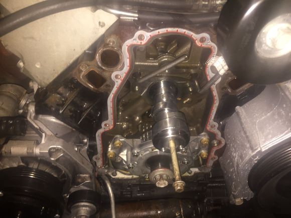 Unbolt the cam gear.... And wiggle it off the cam, you are going to need a heat gun or really hot hair dyer to heat the tnesioner up and make it pliable so you can compress it and put a pin or small allen key in it to keep it compressed....