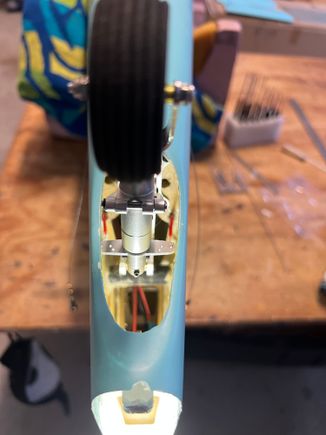 This set up works GREAT in service. However, after flying this aircraft at its first meet I found the moving it around by the tail is tricky. The tail is HEAVY and slips out of your had easily.  One time it dropped and broke the whole retract bulkhead loose!  Had to Hysol it back together at the meet!  Now I use a lanyard looped around the tail to drag it around.