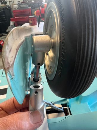 (I shortened my gear doors and haven't repainted yet)
This pic shows the BLIND ROLL PIN (!!) that hold this axle housing on the strut.  I could not believe my eyes when I saw this.  Ultimately I had to thread the center of the roll pin, install a 4-40 bolt and them beat the sh*t ou of the housing to get it to come out.  You'll see I redesigned it.