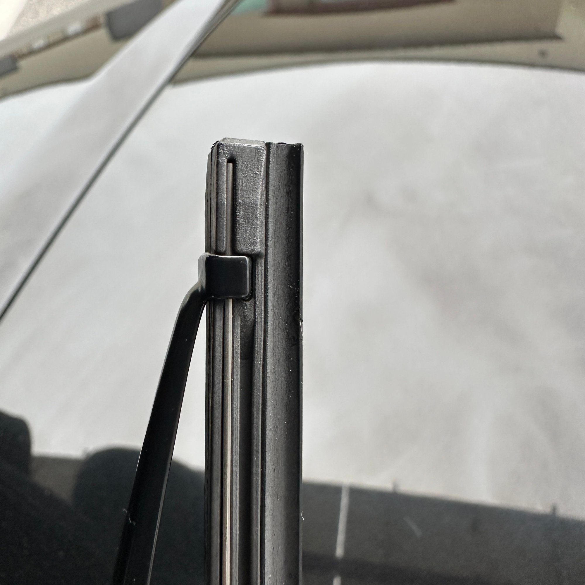 If you look, youll see the inboard-most tab (or the outboard-most tab on the passenger-side arm) locks into place into the rubber insert.