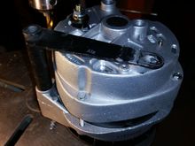 I was going to machine a nice aluminum spacer for the pivot bolt but noticed that the stock spacer/bracket might work if it was straight.  I threw it in my 40 ton press and flattened it- it's really close.