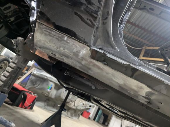 Clean patch in place.  This was done on both side to repair the leading edge of the rocker on the driver's side and fix the major dents where people decided it was a good idea to jack up the car by the rocker.